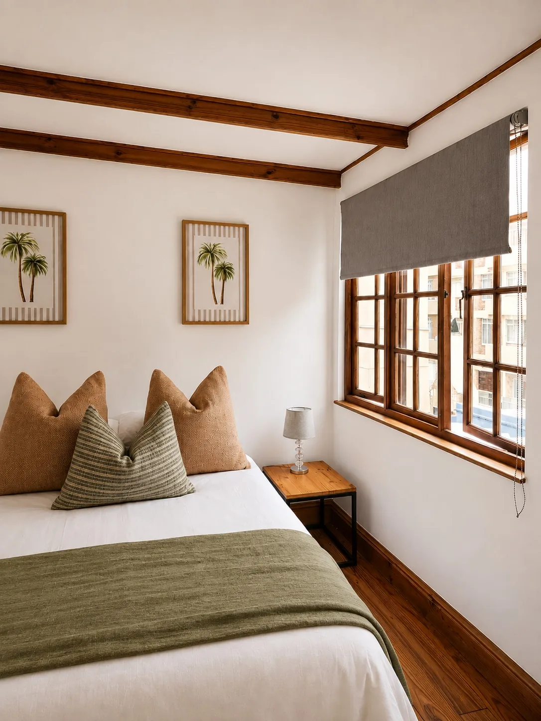 Comfortable additional bedroom at Loddeys Family Room with a double bed, palm artwork and wooden-framed window