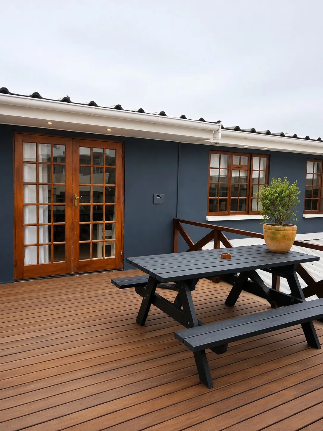 Private wooden patio at Loddeys Family Room with picnic table, bench seating and French doors