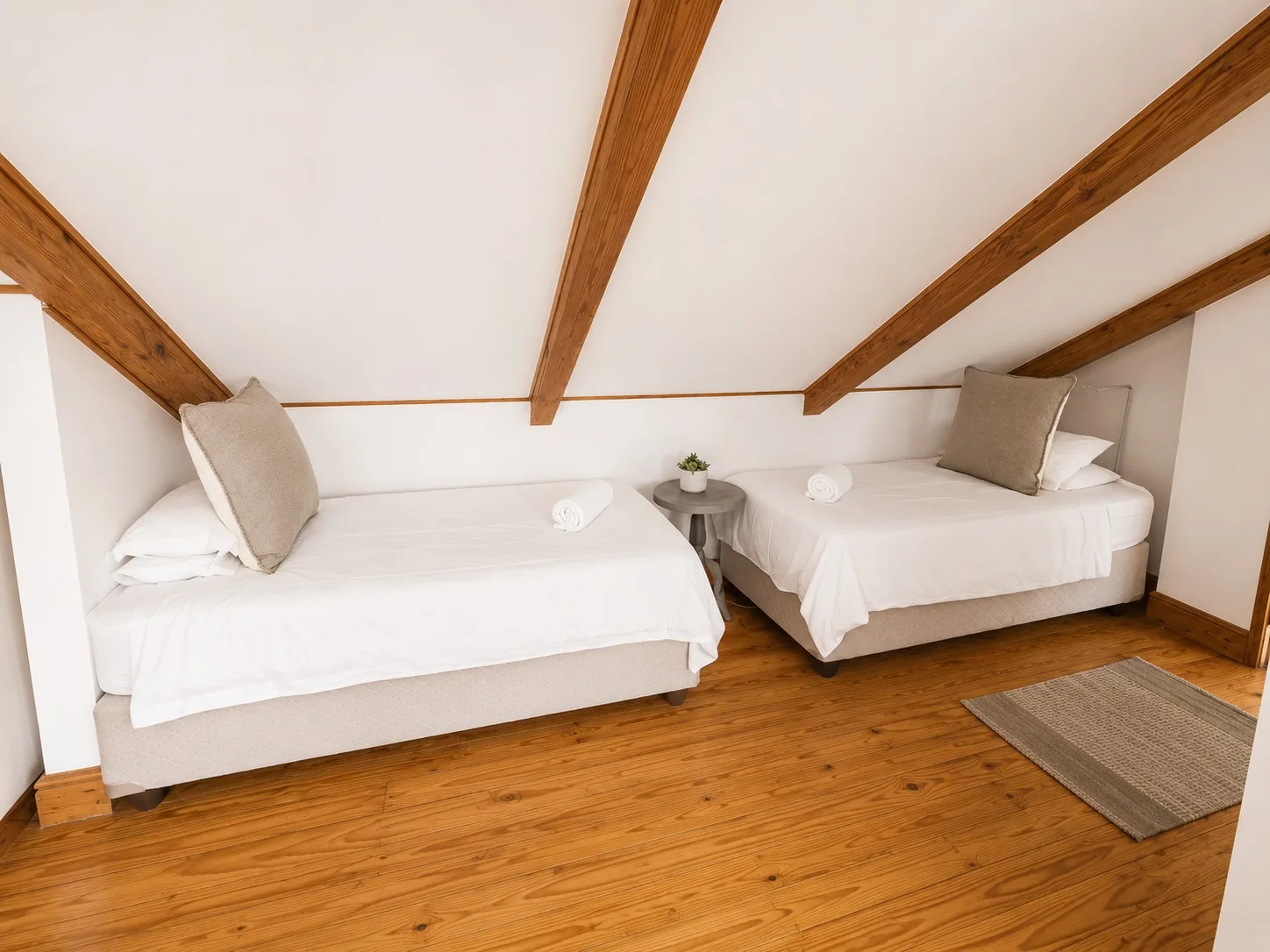 Bright twin bedroom at Loddeys Family Room with two single beds, white bedding and exposed wooden beams
