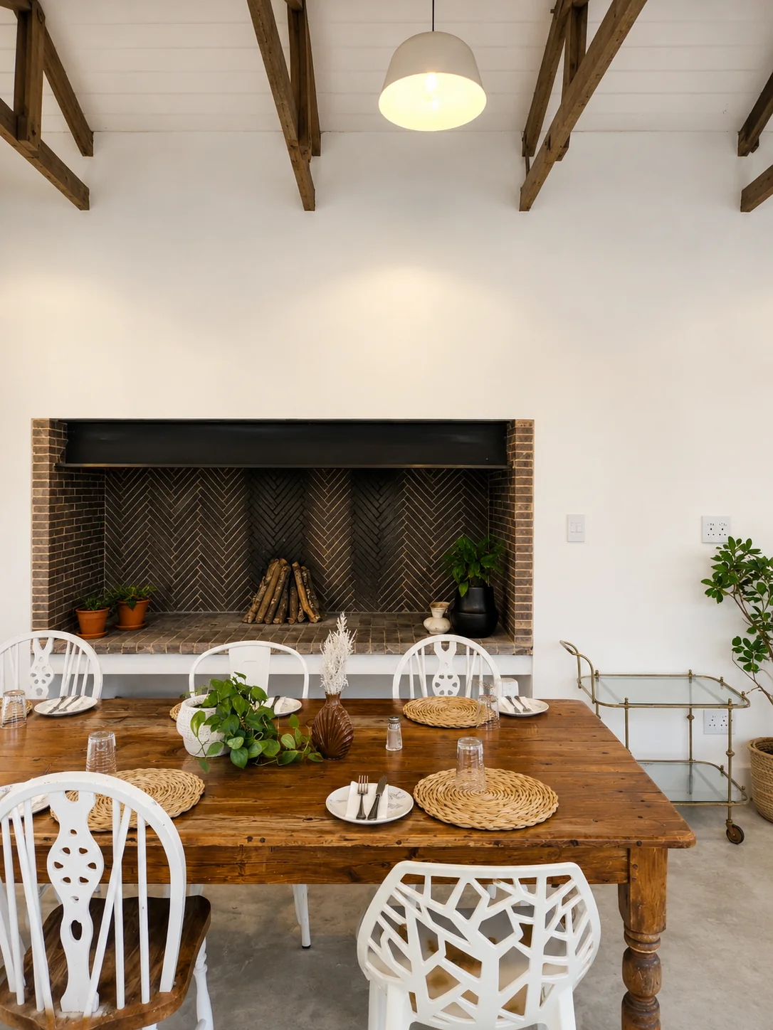 Rustic restaurant dining table set beside a large herringbone brick fireplace